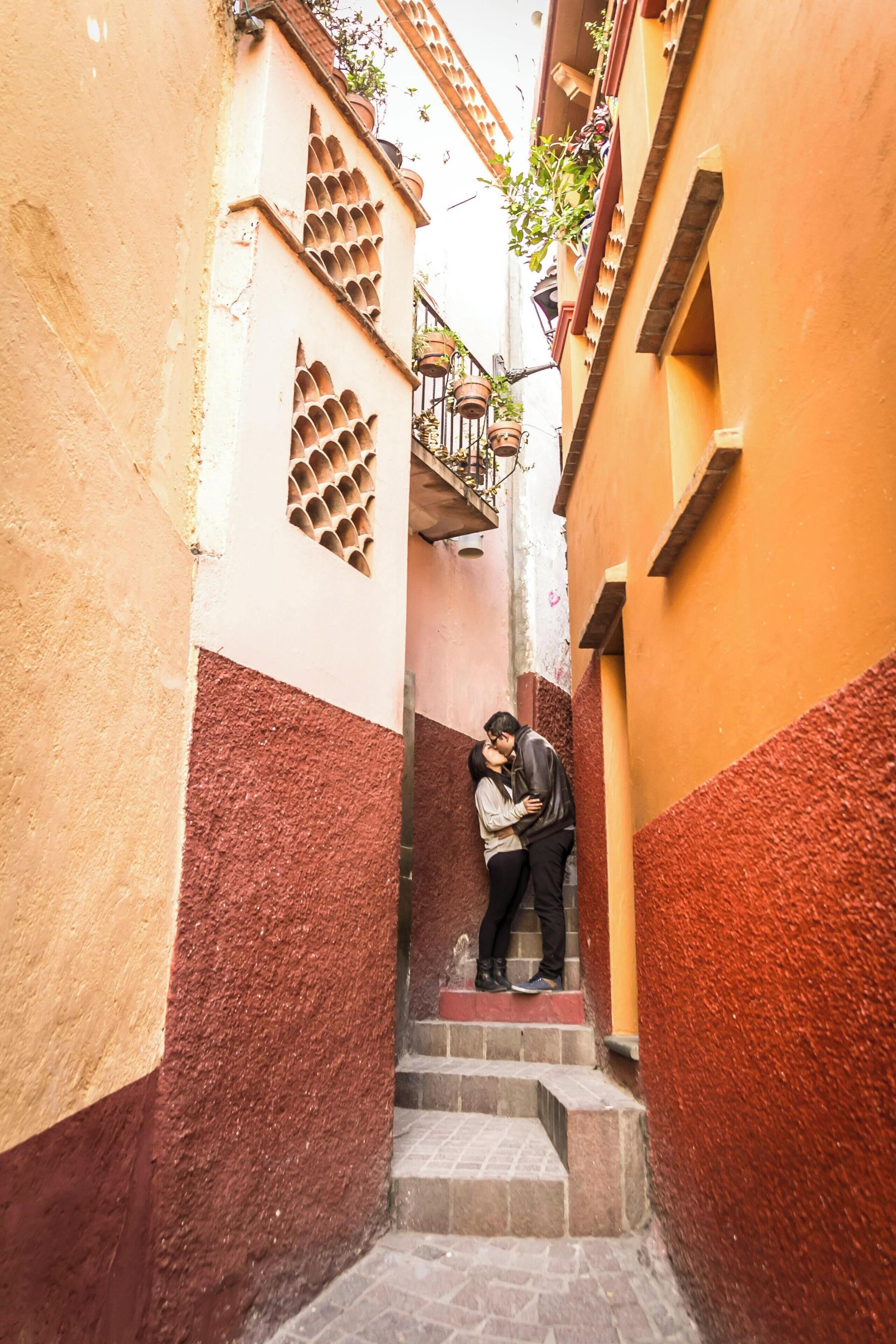 Une ruelle étroite avec un escalier menant à un balcon.