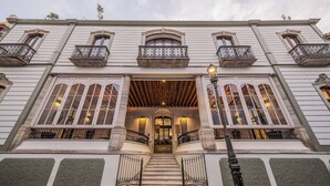 A grand entrance with a wooden staircase, large windows, and ornate railings. - Casa Kloster Hotel Boutique (Guanajuato)