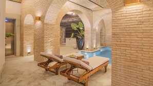 A spa area with two wooden loungers, a small pool, and brick walls. - Casa Kloster Hotel Boutique (Guanajuato)