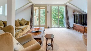 A spacious living room with a high ceiling, a large window, and a sliding glass door leading to a balcony. - Casa BowWow - UK48047 (Rudry, near Cardiff)