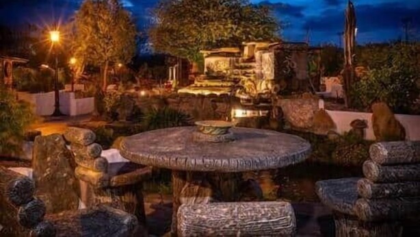 A stone fountain, a circular stone table, and a stone bench in a garden at night. - The Hideaway Muff - Private estate, Shebeen, Lough Foyle (Muff)