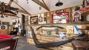 A rustic interior with wooden walls, a slanted ceiling, and various memorabilia. - The Hideaway Muff - Private estate, Shebeen, Lough Foyle (Muff)
