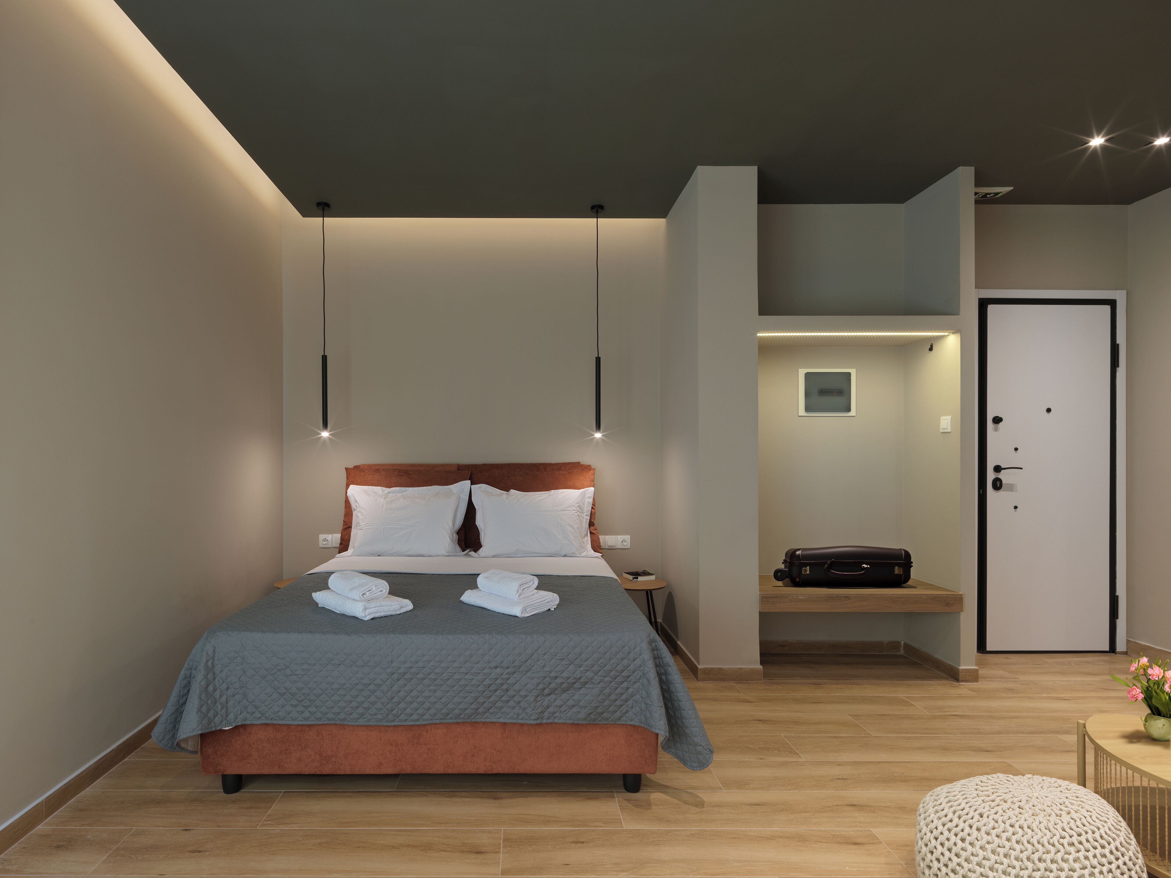 Habitació d'hotel moderna amb llit, taula de nit i zona de seients petita.