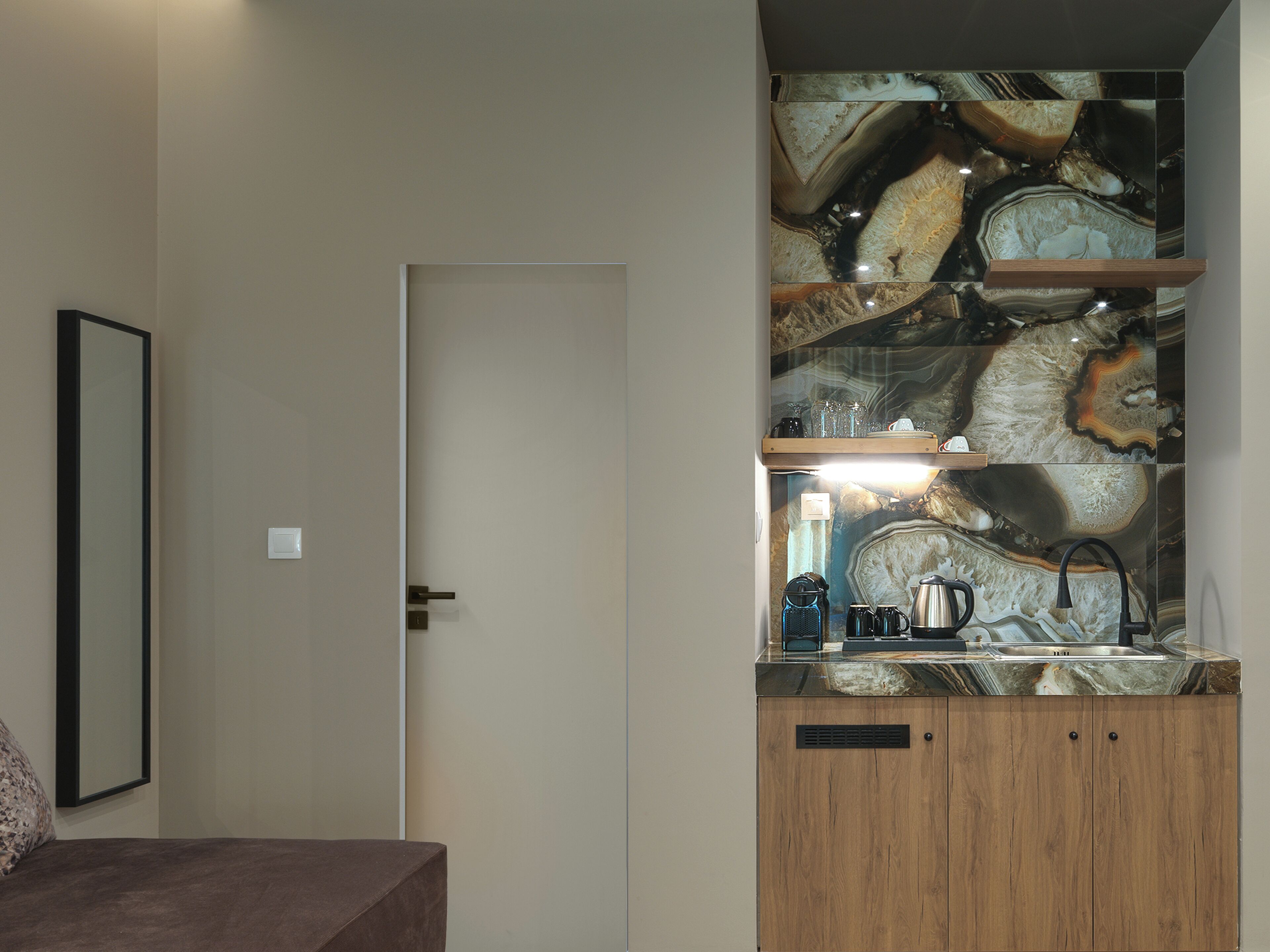 Eine moderne Küche mit Marmor-Spritzschutz, Holzschränken und einer Arbeitsplatte mit Küchengeräten.