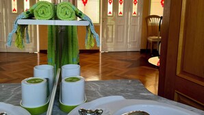 Ein Badezimmer mit zwei Waschbecken, einem Spiegel und einem Handtuchhalter mit aufgerollten Handtüchern.
