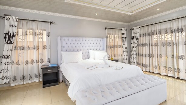 Ein geräumiges Schlafzimmer mit einem großen Bett, einem Nachttisch und einer Bank.