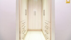 Ein schmaler Flur mit einem hellen Holzschrank und Kommoden an beiden Seiten.