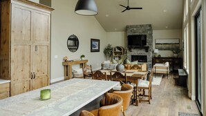 A spacious kitchen with a large island, wooden cabinets, and a stone fireplace. - NEW charming 3 bedroom cottage nestled on the scenic Red Lodge Golf Course  (Red Lodge)