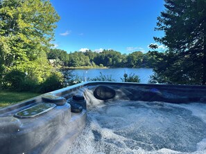 Un jacuzzi con vistas a un lago y árboles.