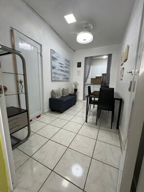 Une pièce comprenant un coin repas, un canapé, un bureau et un grand tableau accroché au mur.