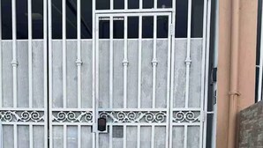 Une grille métallique composée de barreaux verticaux et d’éléments décoratifs.