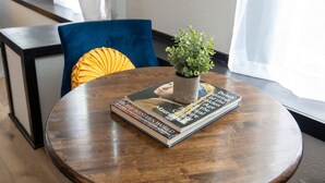 A round wooden table with a potted plant and a stack of books. - Cozy studio in enchanting downtown Warrensburg with full kitchen, AC, WiFi (Warrensburg)