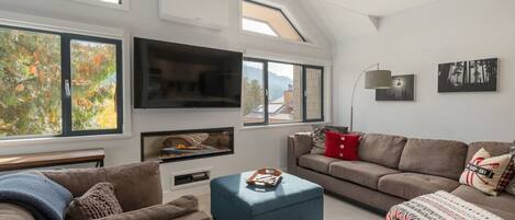 TV connectée, cheminée, livres, chaîne hi-fi