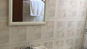 A bathroom with a white sink, a mirror, and a toilet. - Detached, fully furnished cabin with a terrace and barbecue, just steps from Playa Negra, (Concón)