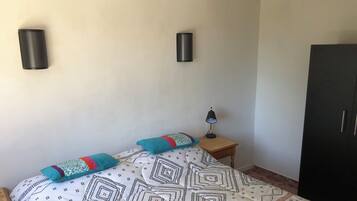 Una camera da letto con un letto, due comodini, una lampada e un armadio.