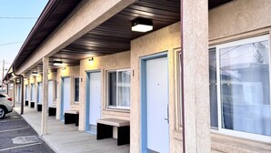 A row of motel rooms with individual doorways, a parking lot, and a car parked outside. - Bryce Park Inn (Panguitch)