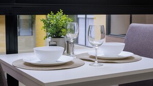 A dining table set with white bowls and wine glasses, a small potted plant, and a salt shaker. - New y modern apto In Virrey (Bogotá)