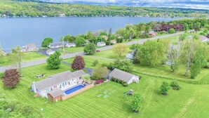 A residential area with houses, a swimming pool, and a lake in the background.