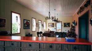 A spacious kitchen with a wooden island, large windows, and a chandelier. - Antique Mountain Cabin (Ponce)
