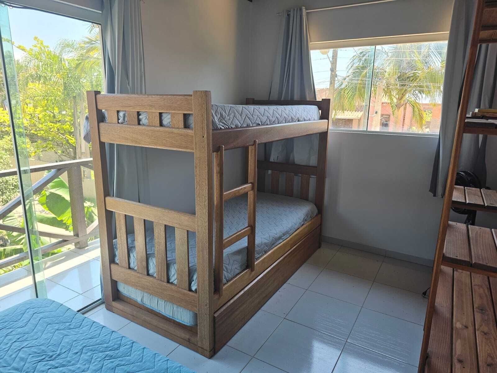 A bunk bed room with a view of greenery outside.