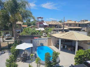 A residential area with a swimming pool, patio furniture, and a gazebo.