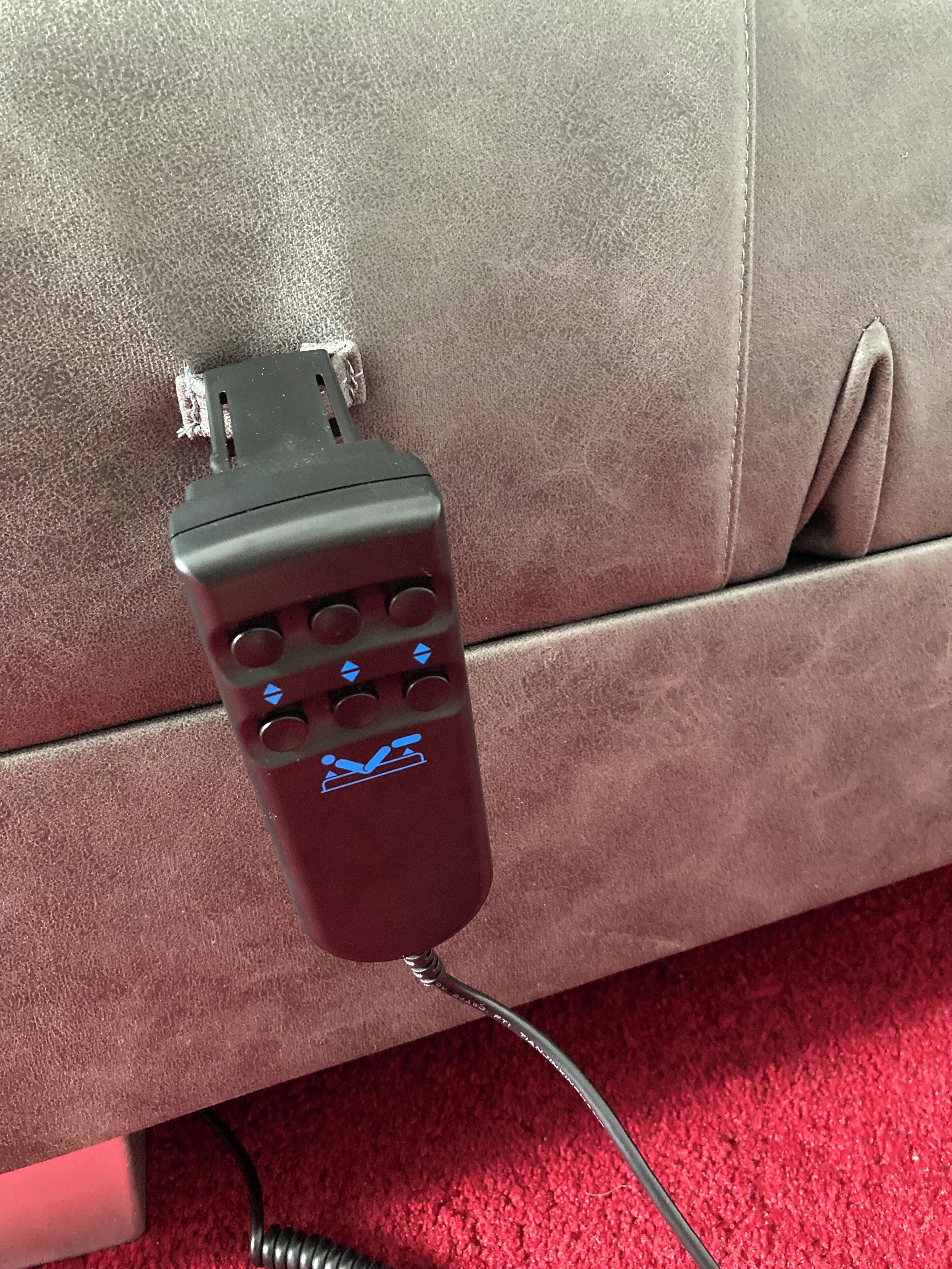 Eine Mehrfachsteckdose mit angeschlossenem Kabel auf einem braunen Ledersofa.