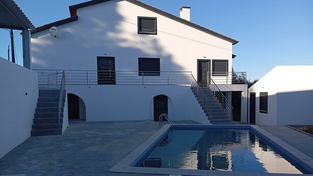 A modern building with a swimming pool, a staircase, and a covered area. - Casa da Avó Bia (Penhascoso)