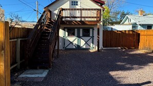 Ett tvåvåningshus med en veranda på framsidan, en trätrappa och ett garage.