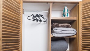Un petit placard en bois, doté d’étagères, de tiroirs et d’une tringle pour suspendre les vêtements.