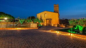 A paved courtyard with a building, a fence, and greenery. - Holiday Home 'Masia Can Divi' with Mountain Views, Wi-Fi and Air Conditioning (Ametlla del Valles)