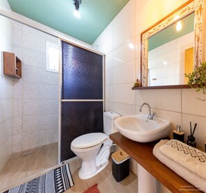 Une salle de bain moderne équipée d’une douche, de toilettes, d’un lavabo et d’un miroir.