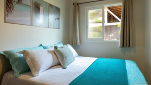Un dormitorio con cama, ventana con cortinas y decoración en la pared.
