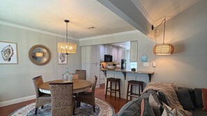 A dining area with a round table, chairs, and a patterned rug.