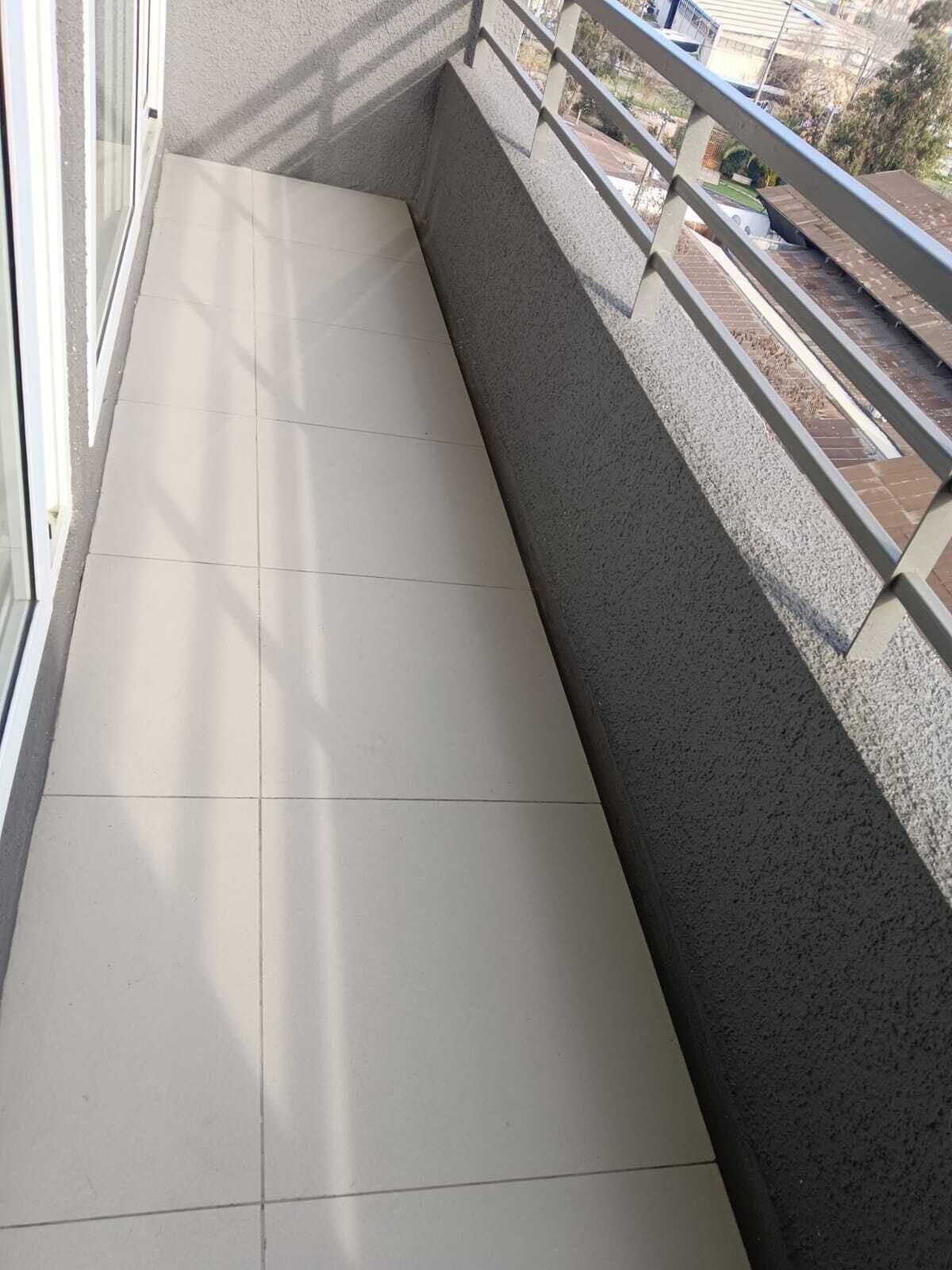 A balcony with a tiled floor and a metal railing.