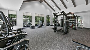 Een moderne sportschool met loopbanden, een gewichtbank en diverse fitnessapparaten.