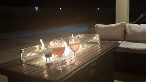 Una mesa de vidrio con dos copas de vino y una vela.
