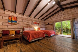 Una habitación con dos camas, un banco de madera y un cuadro en la pared.