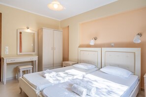 A hotel room with two beds, a desk, a mirror, and a nightstand. - Apartment 'Alex Bar 22' with Sea View, Wi-Fi and Air Conditioning (Parga)