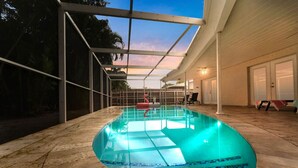 An indoor swimming pool with clear water, surrounded by a covered patio area. - 5BD Beach House, Sun, Pool, BBQ & Shop! Beach & Aventura Mall – Sleeps 26! (Miami)