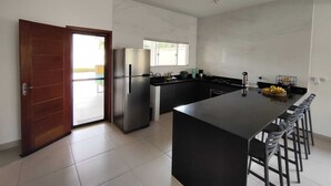 A modern kitchen with a central island, stainless steel appliances, and a large window.