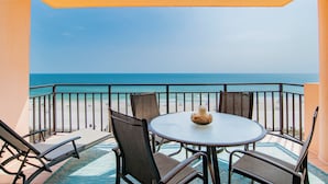 A balcony with a table and chairs, overlooking a beach and the ocean. - Sea Chase Resort, Gulf Front Condo 3 bd/3 ba, Fitness Room, 5 pools, 4 Hot Tubs (Orange Beach)