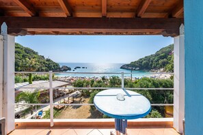 A balcony with a view of a beach and the sea.