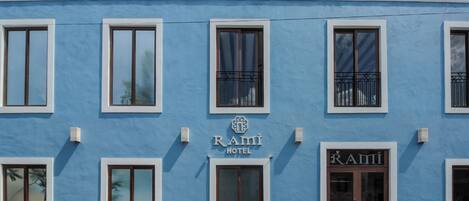 Un edificio azul con varias ventanas y un letrero que dice "Rami Hotel".