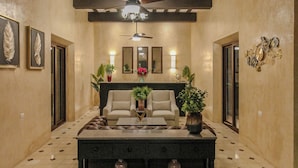A spacious lobby with a high ceiling, a central seating area, and a tiled floor. - HOTEL RAMI (Valladolid)