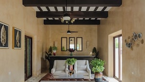 A spacious room with a high ceiling, a fireplace, and a large window. - HOTEL RAMI (Valladolid)