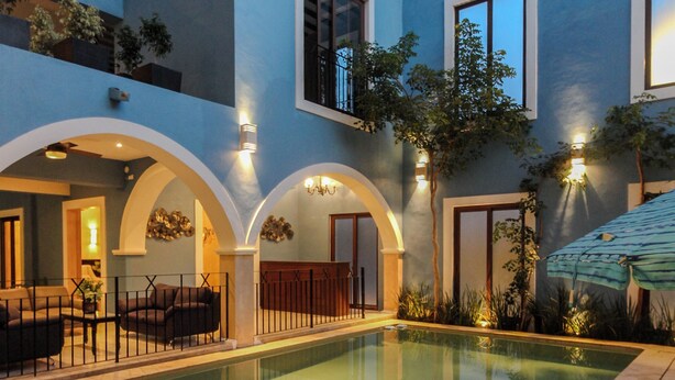 A modern house with a swimming pool, outdoor seating, and a covered patio area. - HOTEL RAMI (Valladolid)