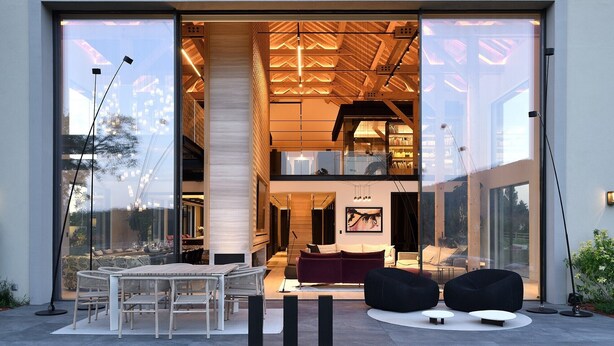 A modern interior with a dining area, seating, and a view through large glass doors.