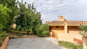 A stone pathway leading to a building with a tiled roof and a satellite dish.