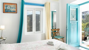 Una habitación con cama, silla, ventana y puerta.