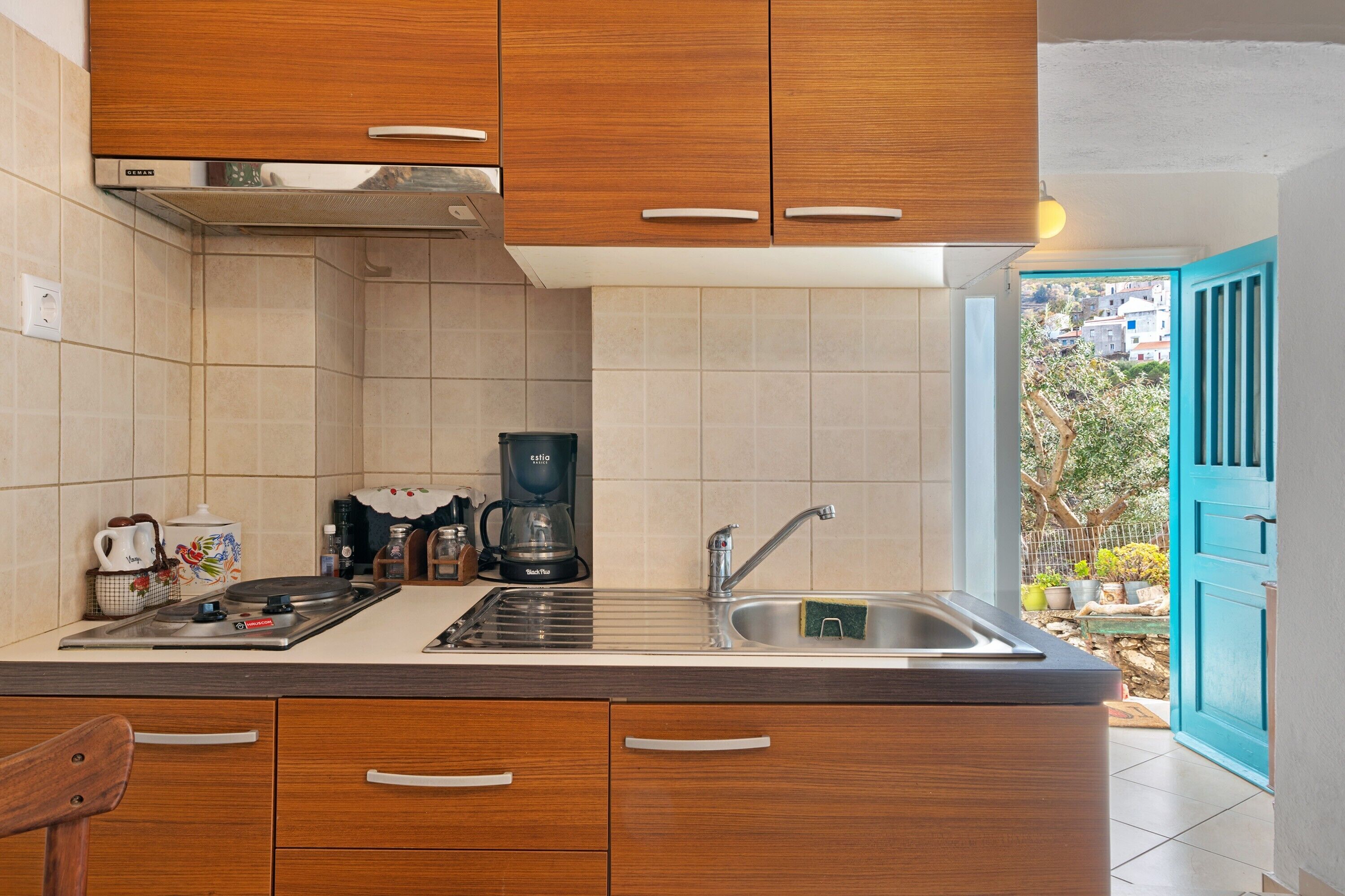 Una cucina con mobili in legno, una macchina da caffè e un lavello.